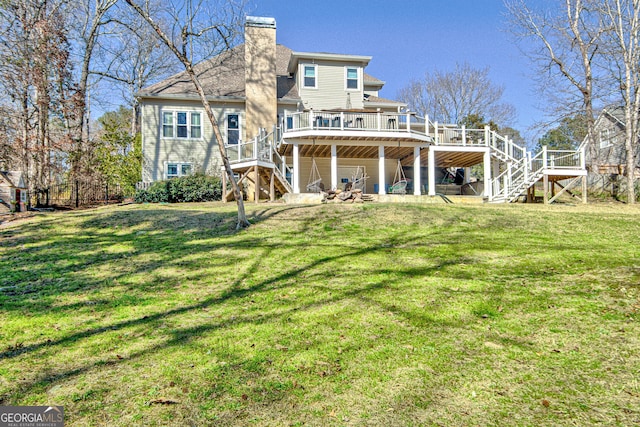 back of house with a deck, a chimney, stairs, and a yard