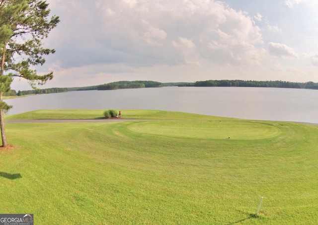 surrounding community with golf course view, a water view, and a yard