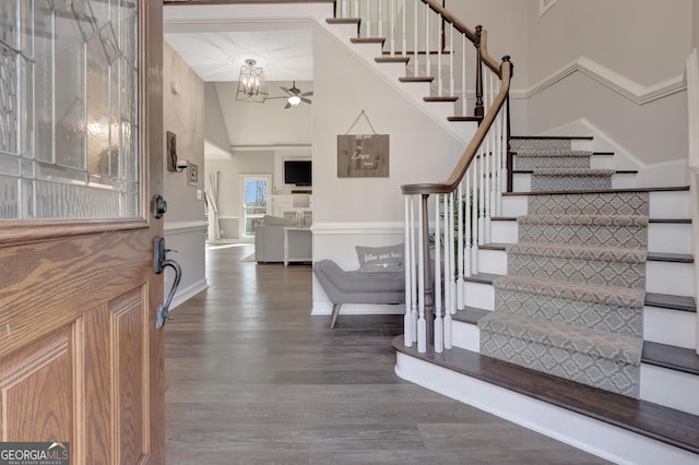 entrance foyer featuring high vaulted ceiling, stairs, ceiling fan, and wood finished floors