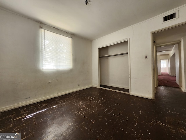 unfurnished bedroom featuring visible vents, baseboards, and a closet