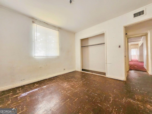 unfurnished bedroom with a closet, visible vents, and baseboards