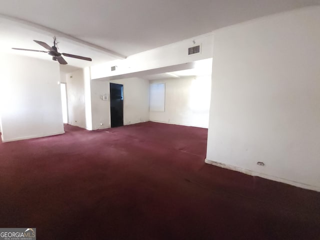 carpeted spare room with visible vents and a ceiling fan