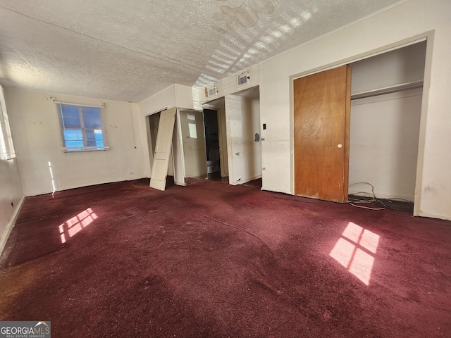 unfurnished living room with carpet and a textured ceiling