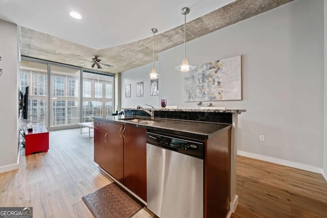 kitchen featuring a sink, dark countertops, floor to ceiling windows, light wood finished floors, and dishwasher