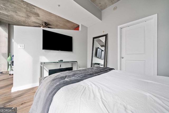 bedroom featuring wood finished floors and baseboards