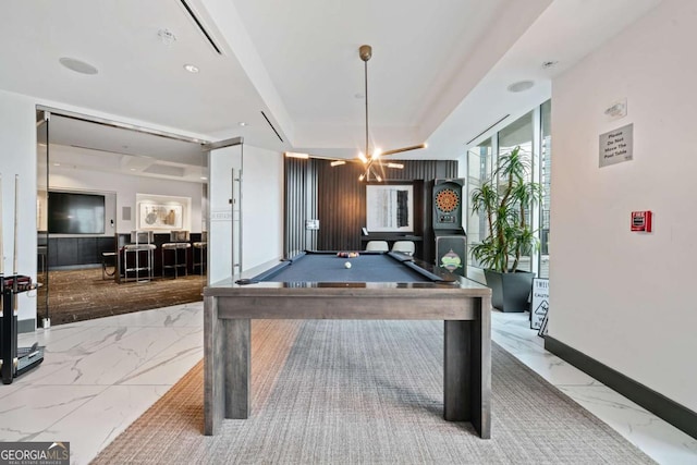 rec room featuring marble finish floor, pool table, baseboards, and a tray ceiling