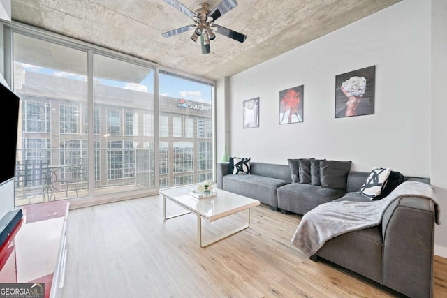 living room featuring a wall of windows, wood finished floors, and ceiling fan