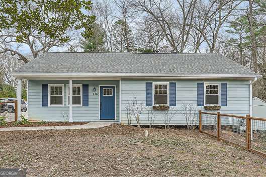 ranch-style house featuring fence and a shingled roof