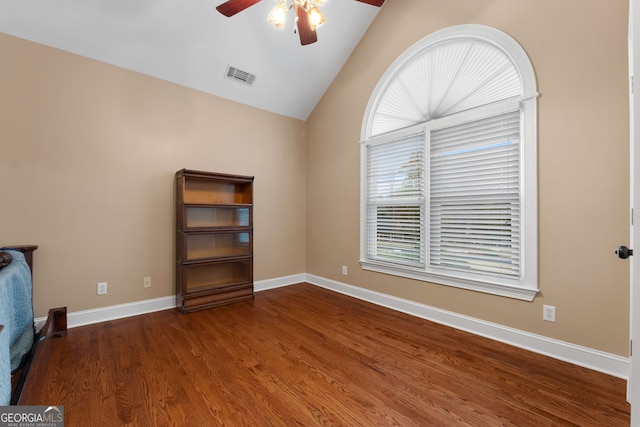 unfurnished bedroom with a ceiling fan, dark wood-style floors, visible vents, baseboards, and vaulted ceiling