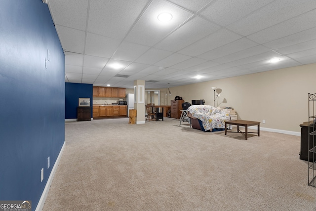 bedroom featuring light colored carpet, baseboards, and a paneled ceiling