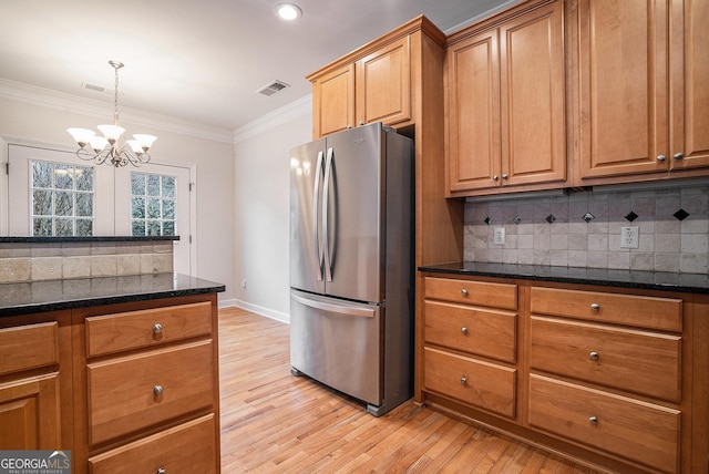 kitchen with visible vents, decorative backsplash, crown molding, and freestanding refrigerator