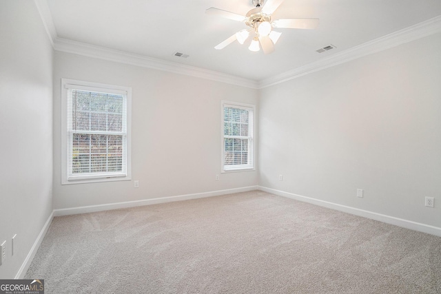 spare room featuring ornamental molding, a healthy amount of sunlight, baseboards, and light carpet