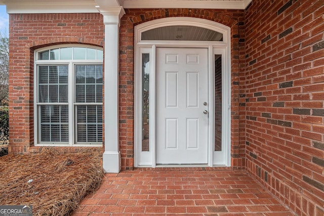 doorway to property with brick siding