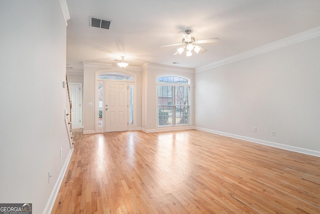 entryway featuring a ceiling fan, visible vents, baseboards, crown molding, and light wood-type flooring