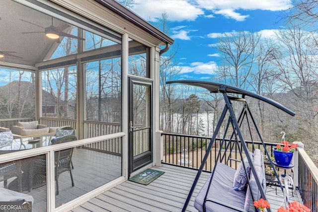 wooden terrace featuring outdoor dining area, a ceiling fan, and a sunroom