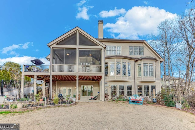 back of property featuring fence, a sunroom, and a chimney