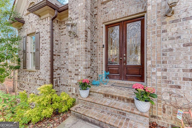 entrance to property featuring french doors and brick siding