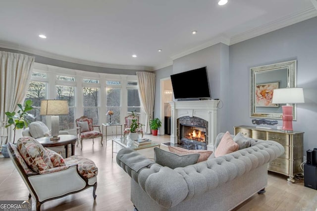 living area with recessed lighting, a premium fireplace, wood finished floors, and ornamental molding