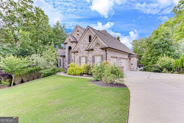 3845 Starboard Pt, Gainesville, GA 30506 - french provincial home with concrete driveway, a front yard, brick siding, a garage, and roof with shingles