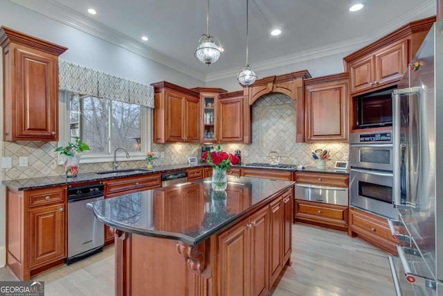 kitchen with a warming drawer, ornamental molding, a sink, appliances with stainless steel finishes, and brown cabinetry