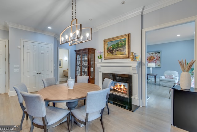 3845 Starboard Pt, Gainesville, GA 30506 - dining area featuring ornamental molding, light wood-style flooring, a chandelier, a glass covered fireplace, and recessed lighting