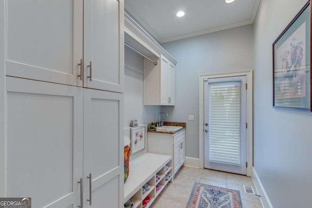 mudroom featuring light tile patterned floors, baseboards, visible vents, a sink, and crown molding