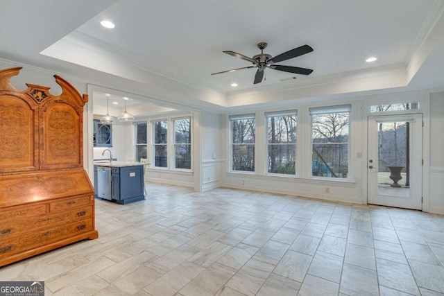 interior space with a raised ceiling and ceiling fan