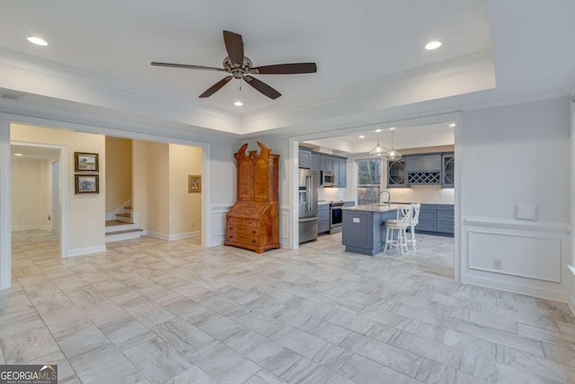 living area with recessed lighting, a raised ceiling, ceiling fan, and stairs