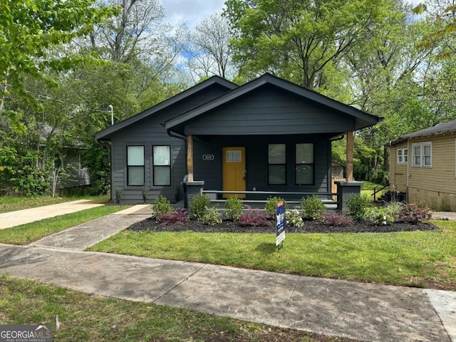 bungalow-style house featuring a front yard and covered porch