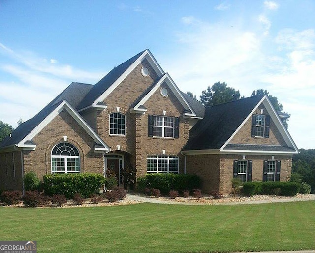 view of front of home with brick siding and a front yard