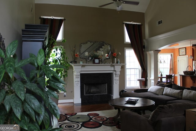 3801 Gold Leaf Ct, Stockbridge, GA 30281 - living area with ceiling fan, a fireplace with flush hearth, a towering ceiling, wood finished floors, and ornate columns