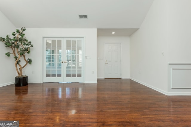 unfurnished living room featuring wood finished floors, visible vents, baseboards, recessed lighting, and french doors