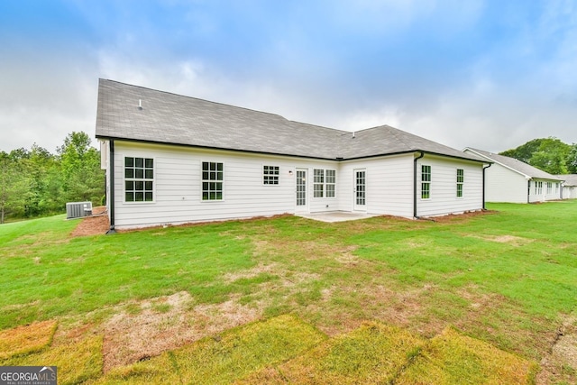 rear view of property with central air condition unit, a patio, and a yard