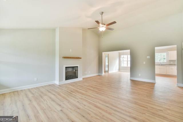 155 Berryman Rd, Hartwell, GA 30643 - unfurnished living room featuring light wood finished floors, a ceiling fan, a glass covered fireplace, and high vaulted ceiling
