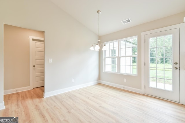 unfurnished dining area with visible vents, baseboards, light wood-type flooring, vaulted ceiling, and an inviting chandelier