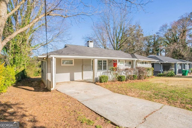 single story home featuring covered porch, driveway, a chimney, and a front yard