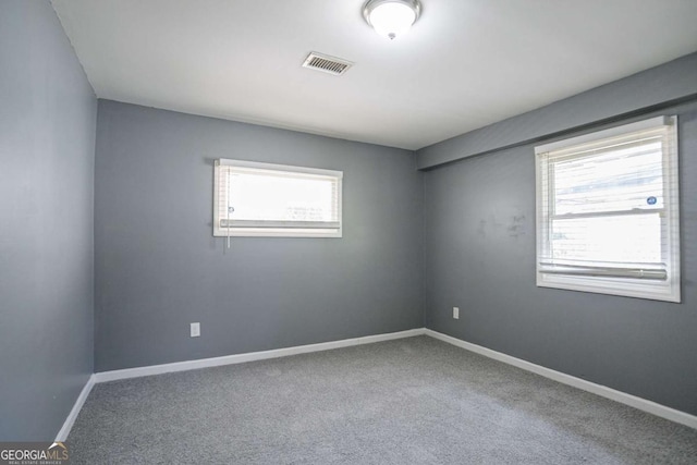 unfurnished room with visible vents, baseboards, and carpet