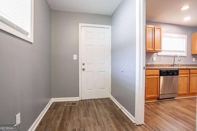 kitchen with dishwasher, dark wood-style floors, baseboards, and a sink