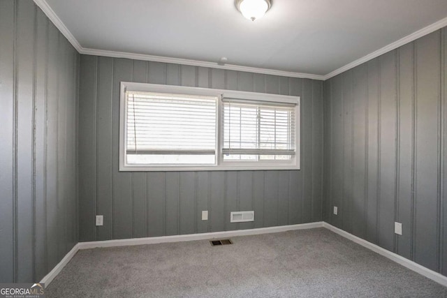 empty room with visible vents, carpet floors, and crown molding