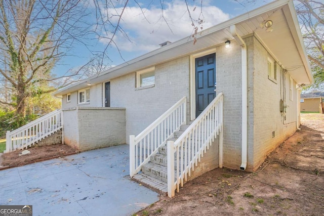 exterior space featuring crawl space, a patio, and brick siding