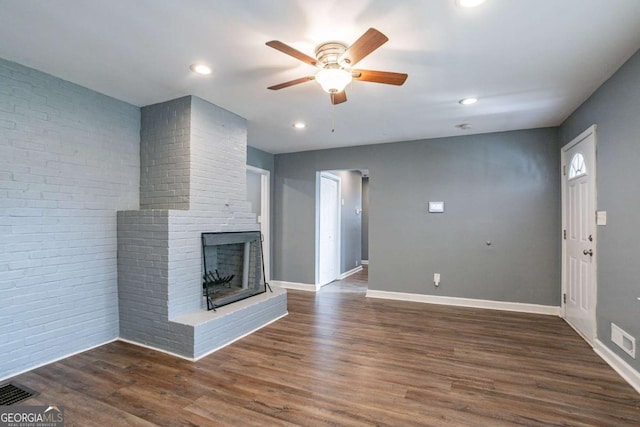 unfurnished living room with visible vents, a fireplace, dark wood-style flooring, and baseboards