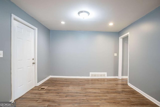 spare room featuring visible vents, baseboards, and wood finished floors