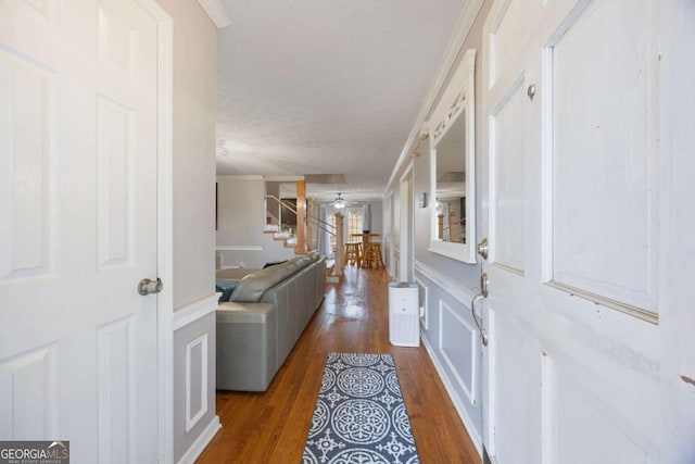 entryway featuring stairs, wood finished floors, a ceiling fan, and crown molding