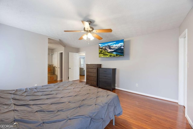 bedroom featuring ceiling fan, baseboards, and wood finished floors