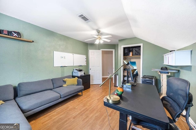 office area featuring light wood-type flooring, visible vents, lofted ceiling, and a ceiling fan