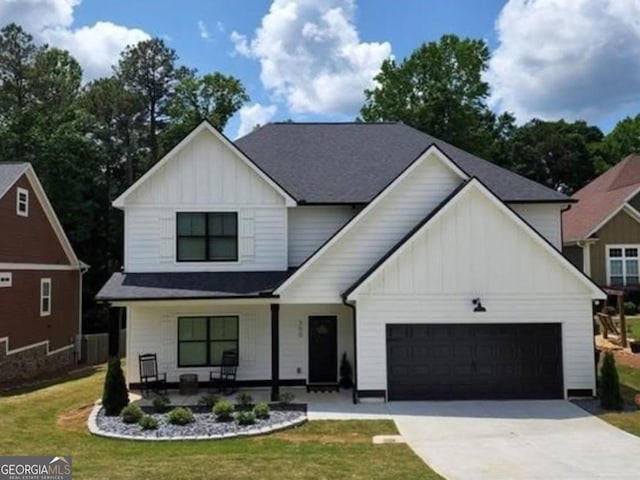 modern farmhouse style home with concrete driveway, a garage, board and batten siding, and a front yard