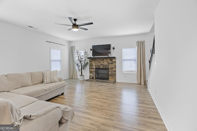 living area featuring a wealth of natural light, visible vents, light wood finished floors, and ceiling fan