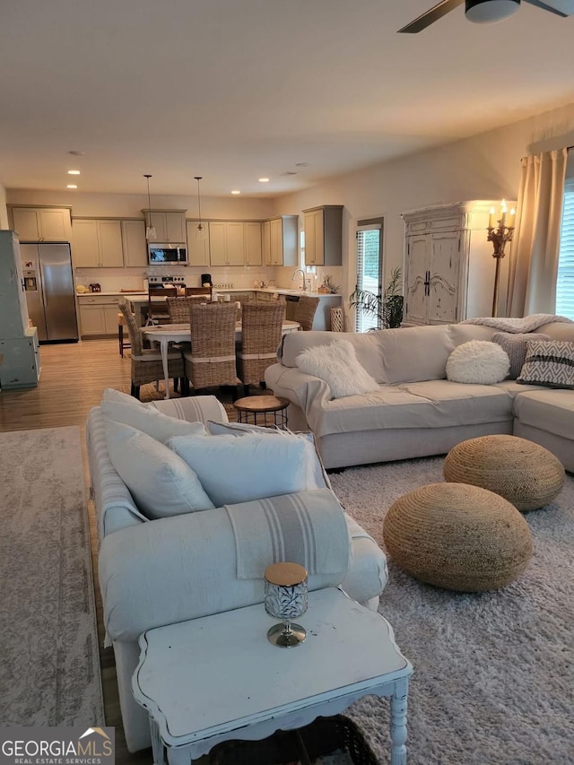 living area featuring recessed lighting, a ceiling fan, and light wood-style floors