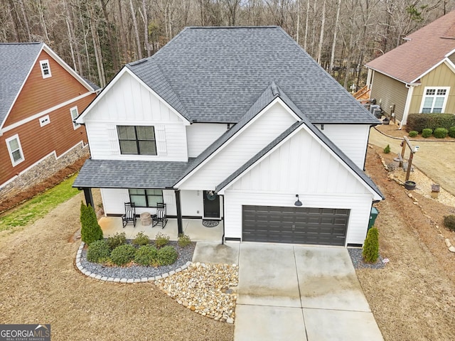 modern inspired farmhouse featuring board and batten siding, a shingled roof, an attached garage, and concrete driveway