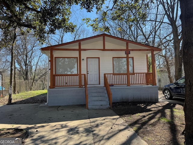 view of front facade with a porch and fence